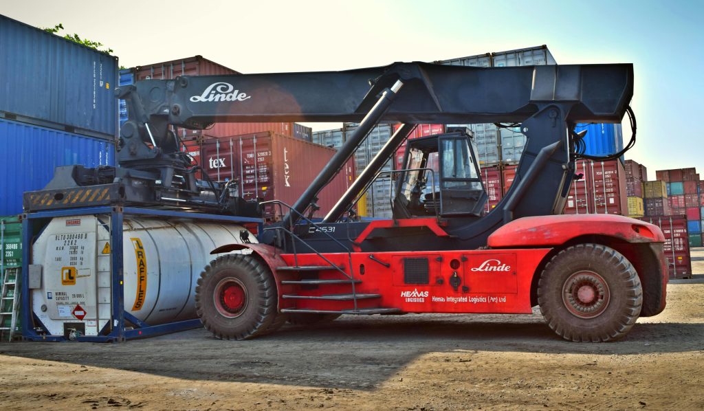Forklift operating at a cargo yard, moving large containers efficiently.